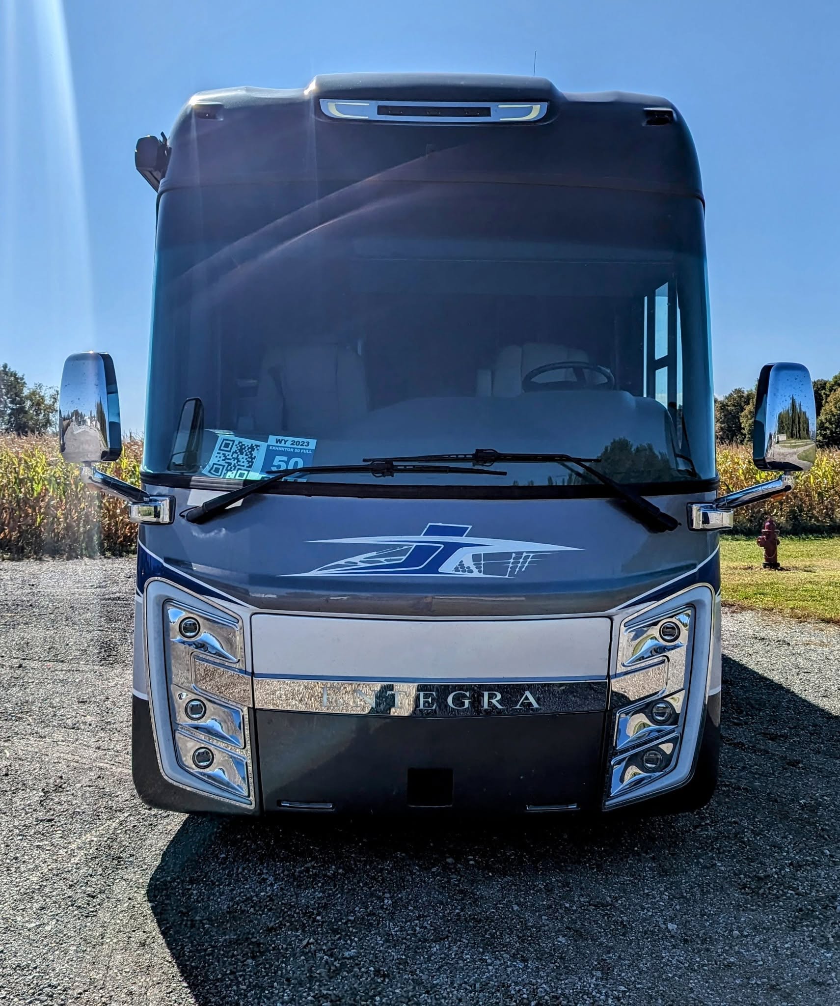 Front of a blue Entegra motorcoach parked outside the shop