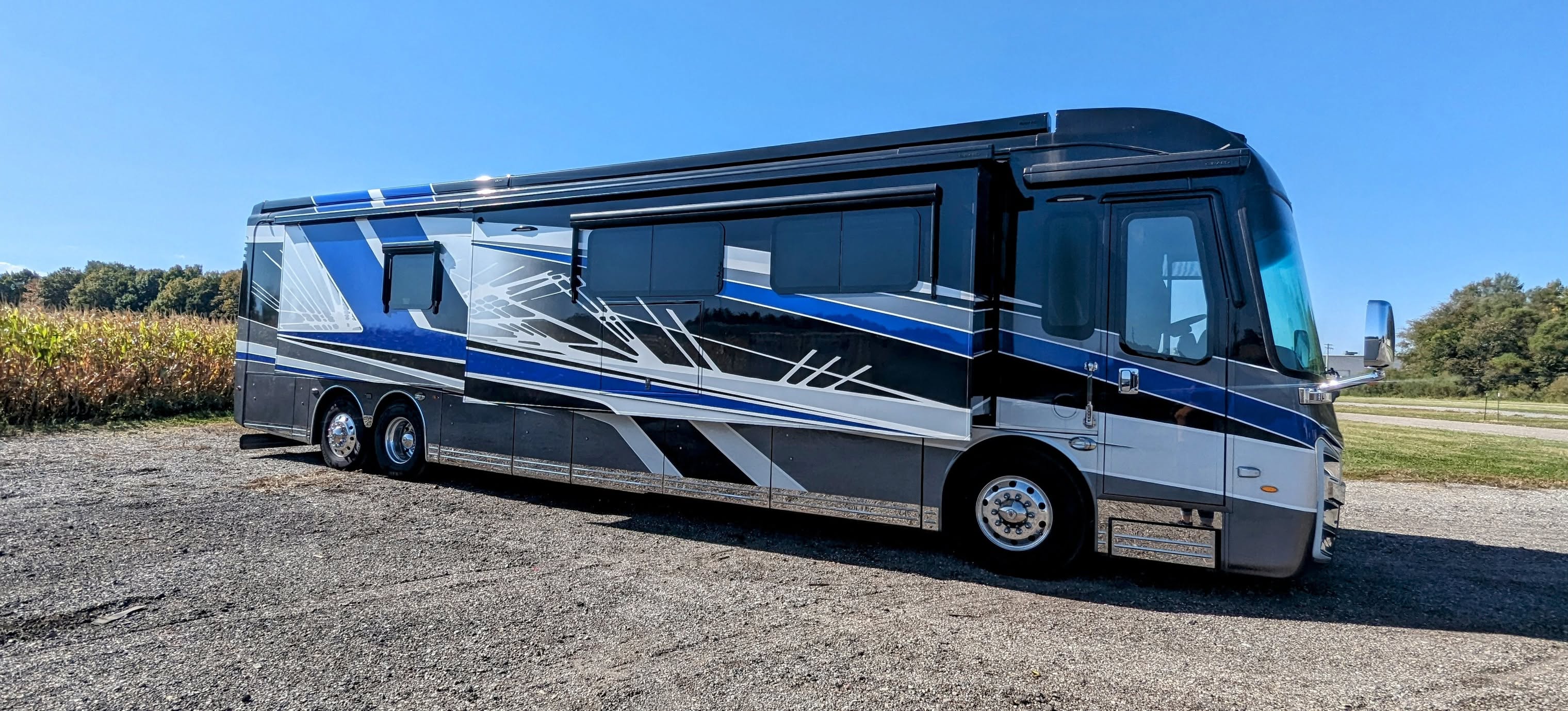Blue, black, and silver motorcoach parked outside